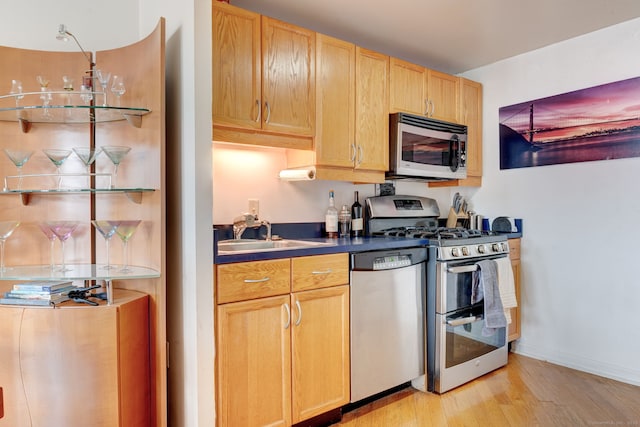 kitchen featuring appliances with stainless steel finishes, light hardwood / wood-style flooring, light brown cabinetry, and sink