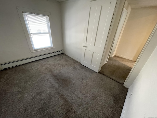 unfurnished bedroom featuring carpet floors and a baseboard radiator