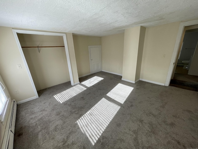 unfurnished bedroom featuring dark colored carpet, a textured ceiling, and a baseboard heating unit