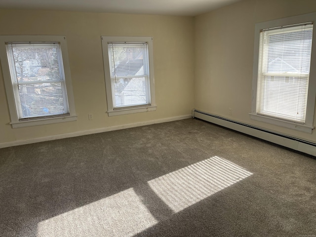 carpeted spare room featuring baseboard heating