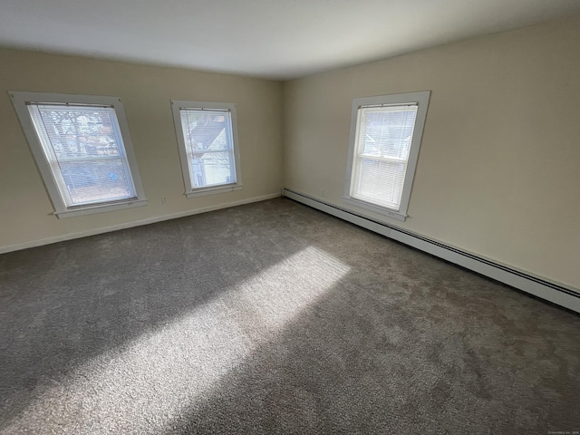 carpeted spare room featuring a baseboard heating unit