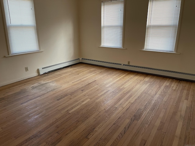 spare room featuring light hardwood / wood-style floors and a baseboard heating unit