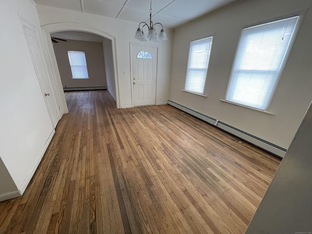 entryway with hardwood / wood-style floors, a baseboard radiator, and ceiling fan with notable chandelier