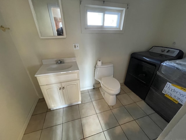 bathroom featuring washer / clothes dryer, tile patterned flooring, vanity, and toilet