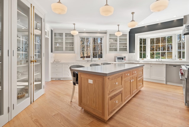 kitchen with white cabinets, decorative backsplash, pendant lighting, and a center island