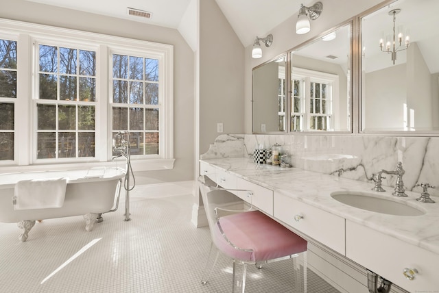 bathroom with vaulted ceiling, a bathtub, tile patterned flooring, tasteful backsplash, and vanity