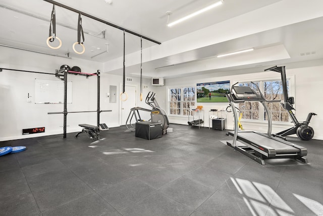 gym with electric panel and a wall mounted air conditioner