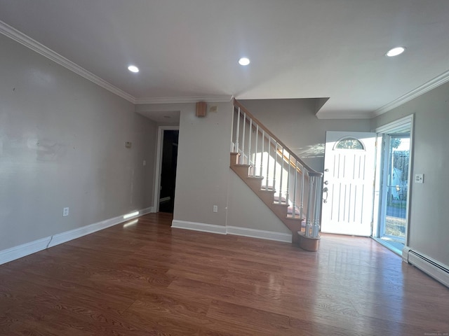 empty room with baseboard heating, crown molding, and dark hardwood / wood-style flooring