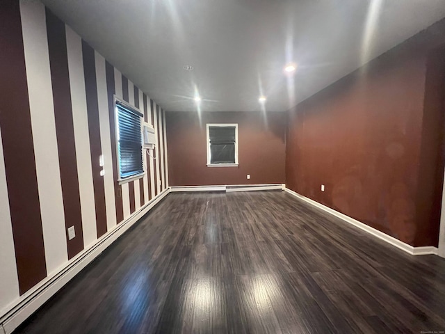 spare room with dark wood-type flooring and a baseboard radiator