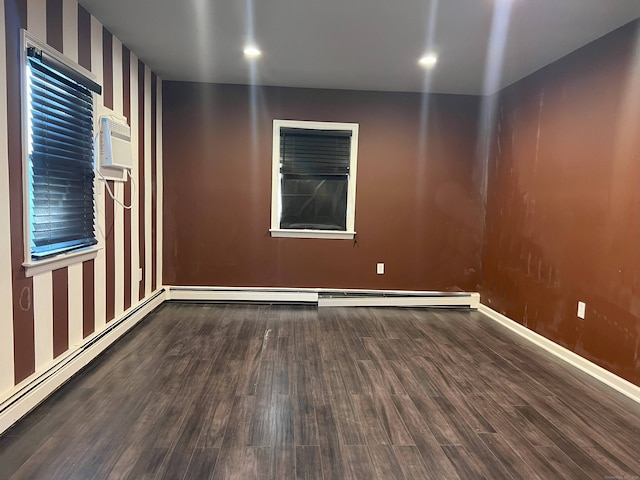 unfurnished room with a wall mounted AC, dark hardwood / wood-style floors, and a baseboard heating unit