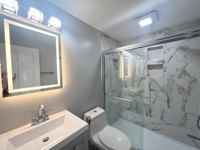 bathroom with vanity, toilet, and a shower with door