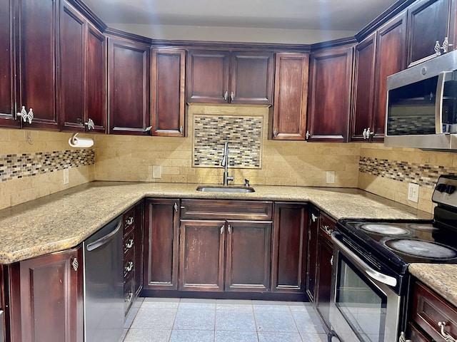 kitchen with backsplash, light tile patterned floors, sink, and appliances with stainless steel finishes