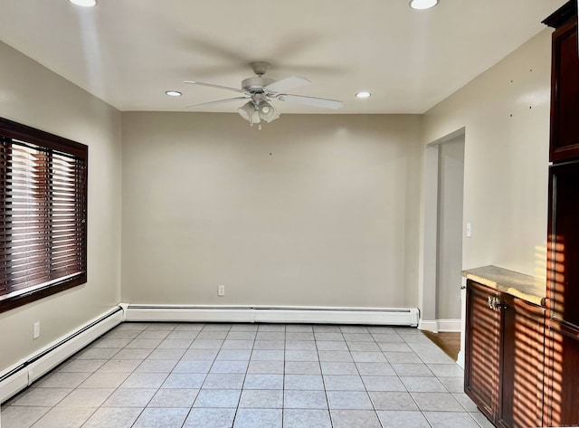 unfurnished room with ceiling fan, light tile patterned floors, and a baseboard heating unit