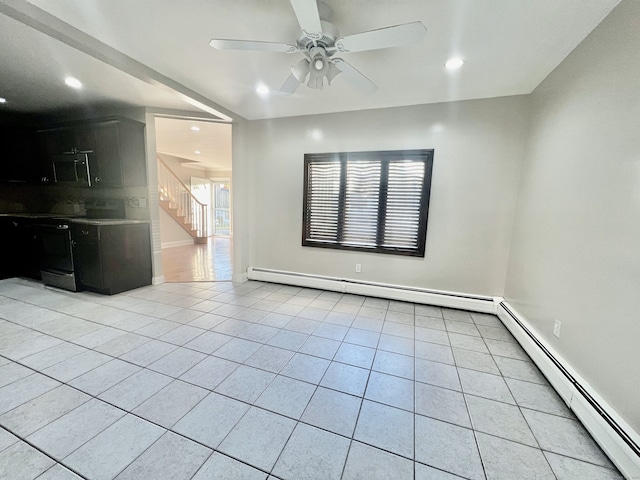 spare room with ceiling fan, light tile patterned floors, and baseboard heating