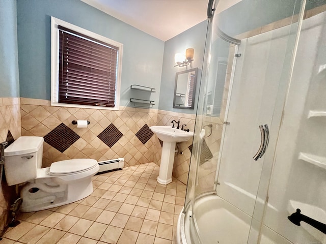 bathroom with tile patterned floors, an enclosed shower, a baseboard heating unit, tile walls, and toilet