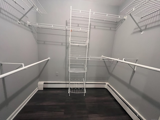 walk in closet featuring hardwood / wood-style flooring and baseboard heating