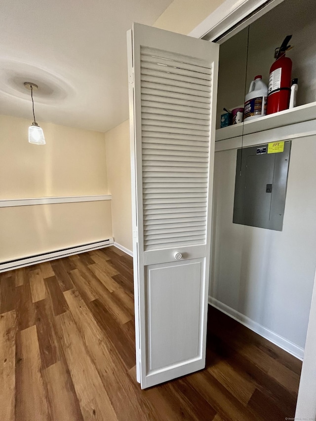 hallway featuring electric panel, wood-type flooring, and a baseboard heating unit