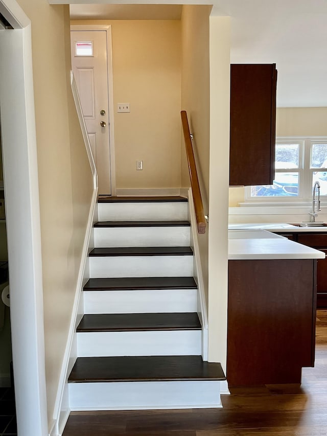 stairway featuring sink and hardwood / wood-style flooring