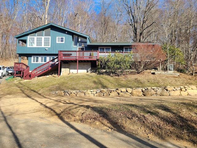 rear view of property with a wooden deck and a yard