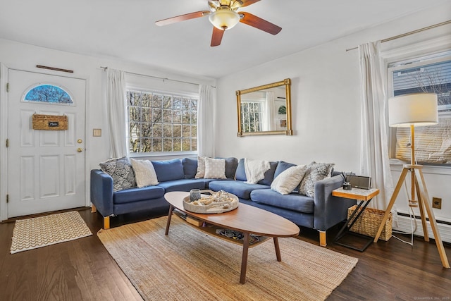 living room featuring a baseboard heating unit, ceiling fan, and dark hardwood / wood-style floors