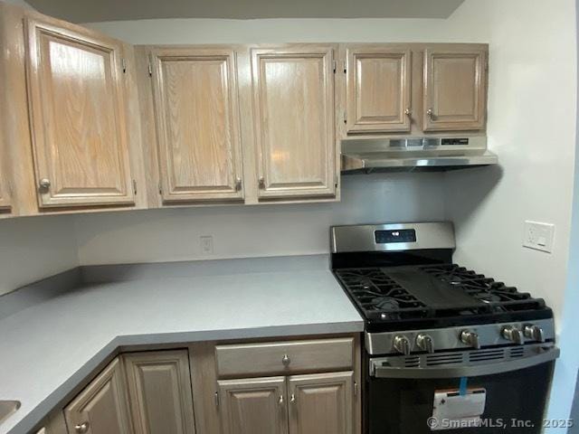 kitchen featuring light brown cabinetry and stainless steel gas range oven