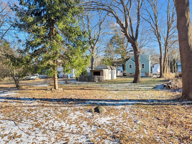 yard layered in snow with a storage shed