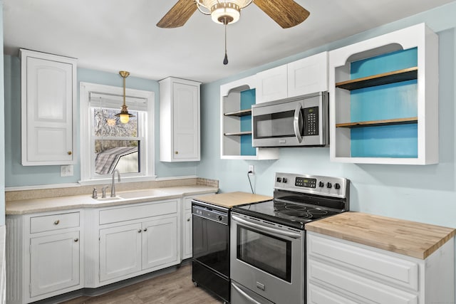 kitchen featuring stainless steel appliances, white cabinets, hanging light fixtures, and sink