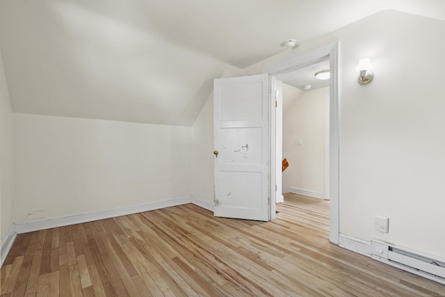 additional living space featuring light hardwood / wood-style floors, a baseboard radiator, and lofted ceiling