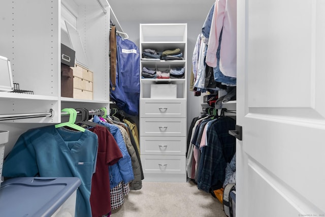 walk in closet with light carpet