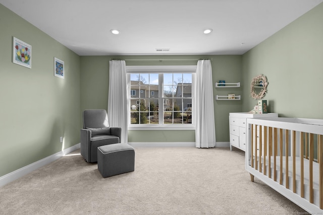 carpeted bedroom featuring a nursery area