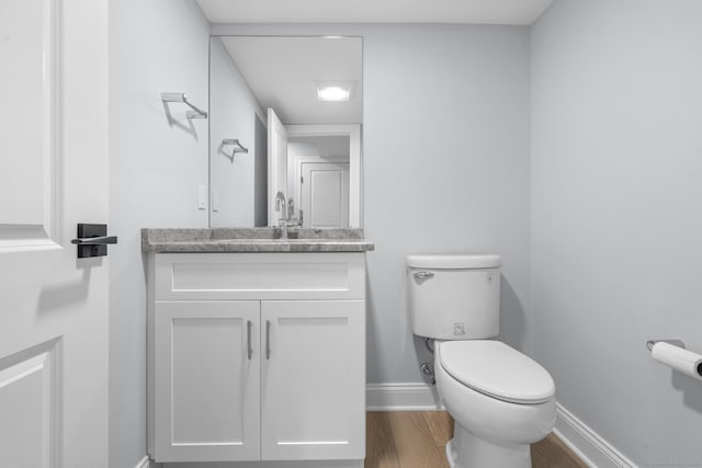 bathroom featuring hardwood / wood-style flooring, vanity, and toilet