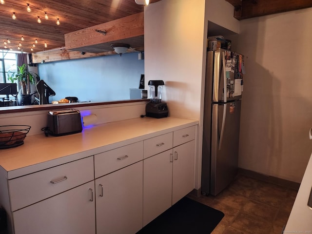 kitchen featuring white cabinets, stainless steel fridge, and wooden ceiling