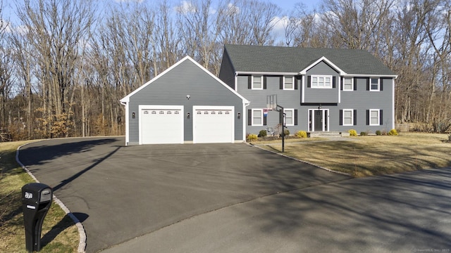 colonial house featuring aphalt driveway and a garage