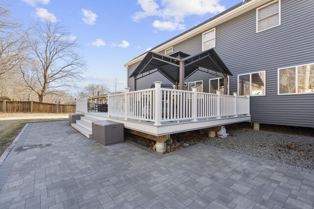 rear view of property featuring a deck, a patio, and fence