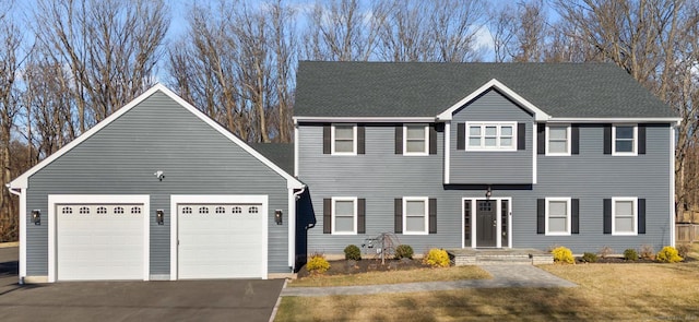 view of front of house featuring aphalt driveway, a garage, and roof with shingles