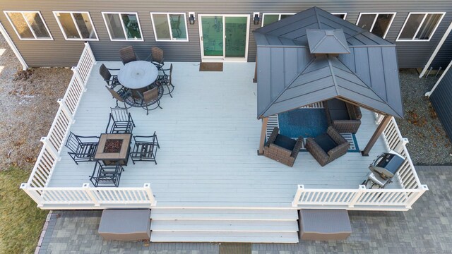 wooden terrace with outdoor dining space and an outdoor fire pit