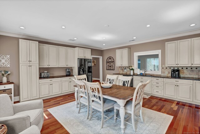 dining space with recessed lighting, light wood-style flooring, and crown molding