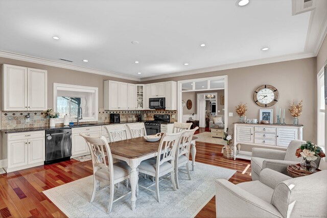 dining room with crown molding, recessed lighting, dark wood-style floors, and visible vents