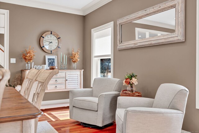 living area featuring wood finished floors and ornamental molding