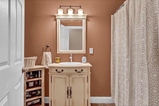 full bathroom featuring vanity and baseboards