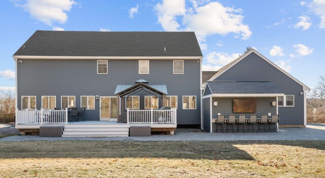 back of house featuring outdoor dry bar, a wooden deck, a yard, and a shingled roof