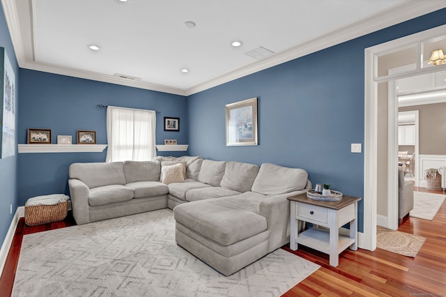 living area featuring recessed lighting, visible vents, wood finished floors, and ornamental molding