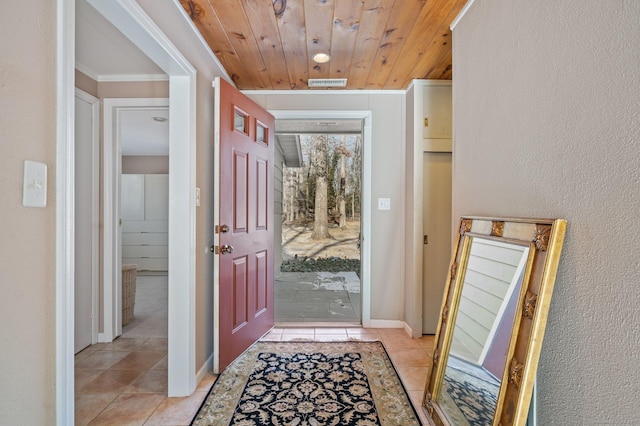 doorway featuring ornamental molding, light tile patterned floors, and wooden ceiling