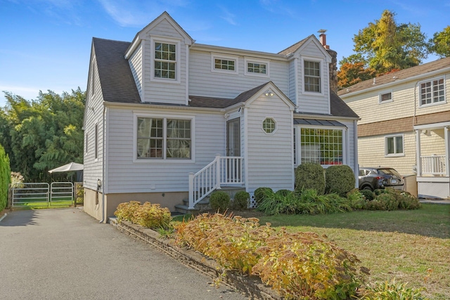 view of front of property featuring a front yard, fence, and roof with shingles