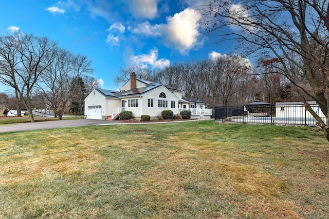 view of front of home with solar panels and a front lawn