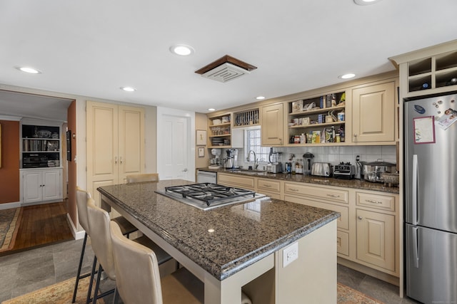 kitchen featuring a center island, sink, appliances with stainless steel finishes, and dark stone counters