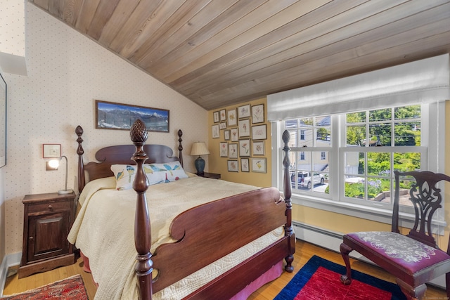 bedroom featuring baseboard heating, light hardwood / wood-style flooring, wood ceiling, and vaulted ceiling