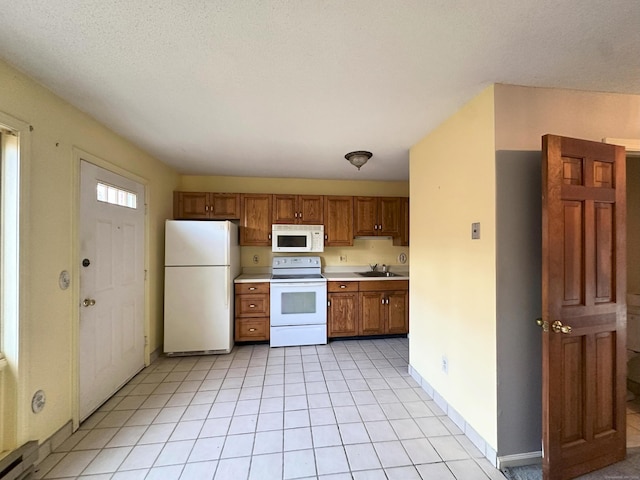 kitchen featuring a textured ceiling, white appliances, a baseboard radiator, and sink