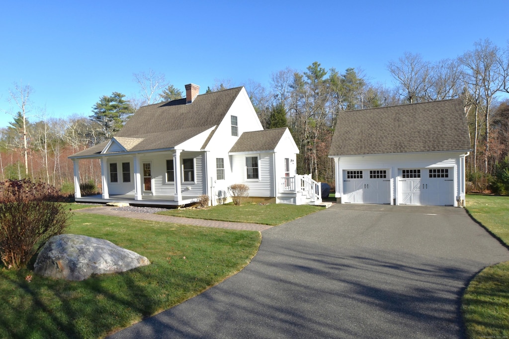 cape cod house featuring a porch and a front lawn