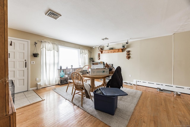 dining area featuring light hardwood / wood-style floors and a baseboard radiator